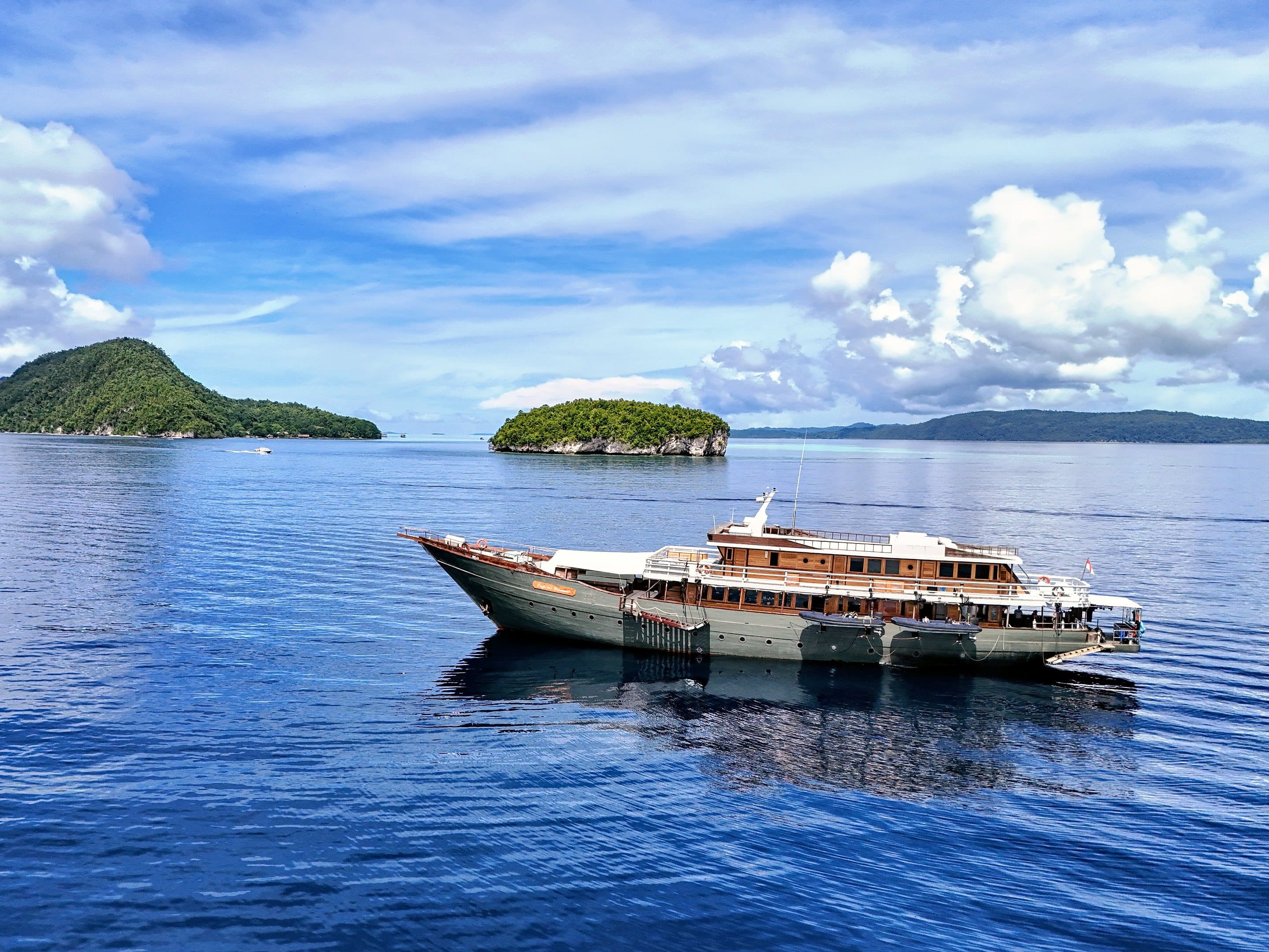 The phinisi Emperor Harmoni at anchor between two islands in Raja Ampat